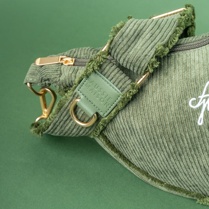 Moon Bag Khaki Cord Crush – detail výšivky AM, poutka s logem a zlatých kování